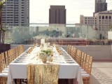 a gold glitter table runner, gold glasses and chairs create a glam look and feel at the reception