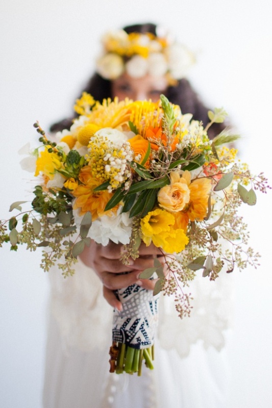 A bold yellow wedding bouquet with white blooms, greenery, billy balls and eucalyptus is a cool option for spring