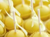 bold yellow cake pops with bows will be nice wedding favors or sweets for the dessert table
