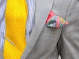 a bold and fun look with a grey plaid suit, a striped shirt and a yellow polka dot tie plus a colorful pocket square and a fun bee brooch