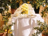 a lemon spring wedding reception with trees around it, with white linens and lemon centerpieces is a chic space