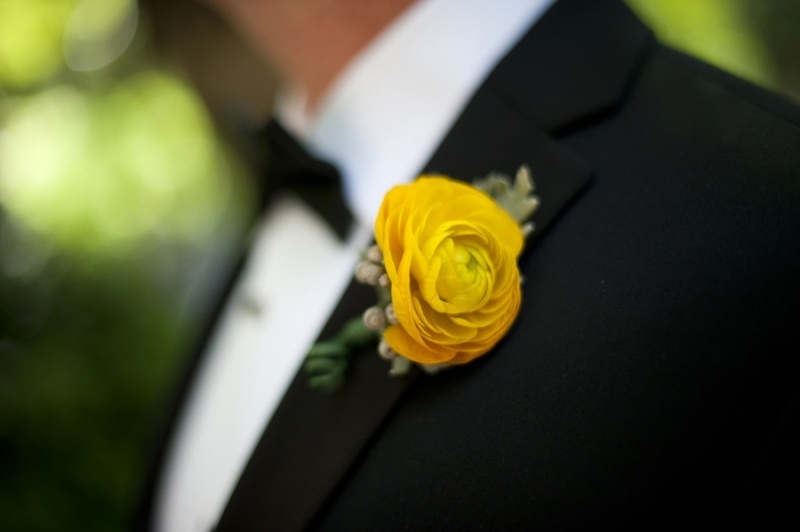 A black tux and a bold yellow boutonniere for an elegant and chic look at the wedding