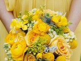 a yellow draped bridesmaid dress with a sash and a matching bouquet with thistles and greenery