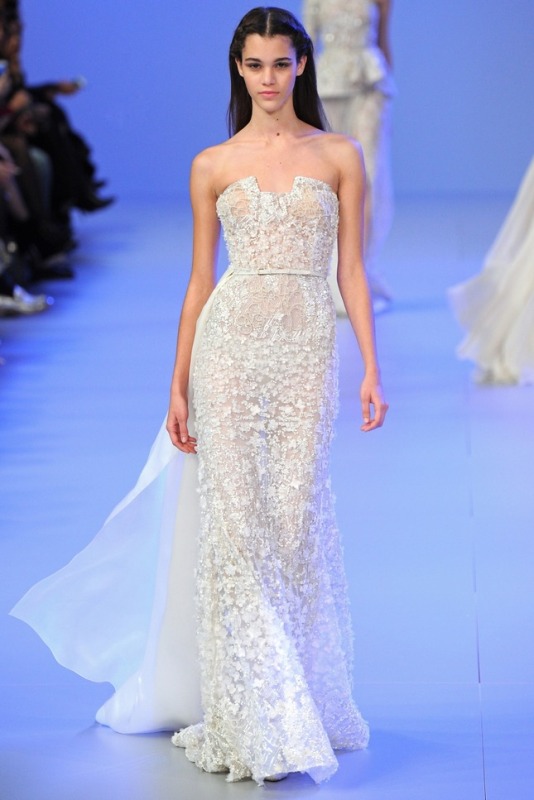 A semi sheer lace embellished sheath wedding dress with a sculptural bodice and a train is a lovely and very glam idea