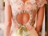 a romantic keyhole back with embellishments, fabric blooms in pink and a green ribbon bow is super cute