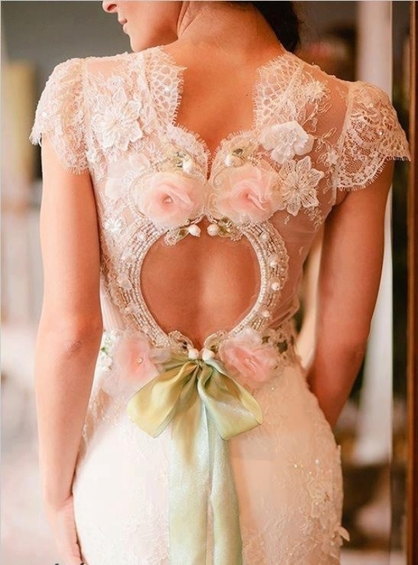 A romantic keyhole back with embellishments, fabric blooms in pink and a green ribbon bow is super cute