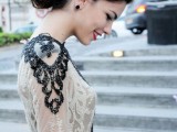a nude lace wedding dress with heavily embellished shoulders in black that make a bold and chic statement