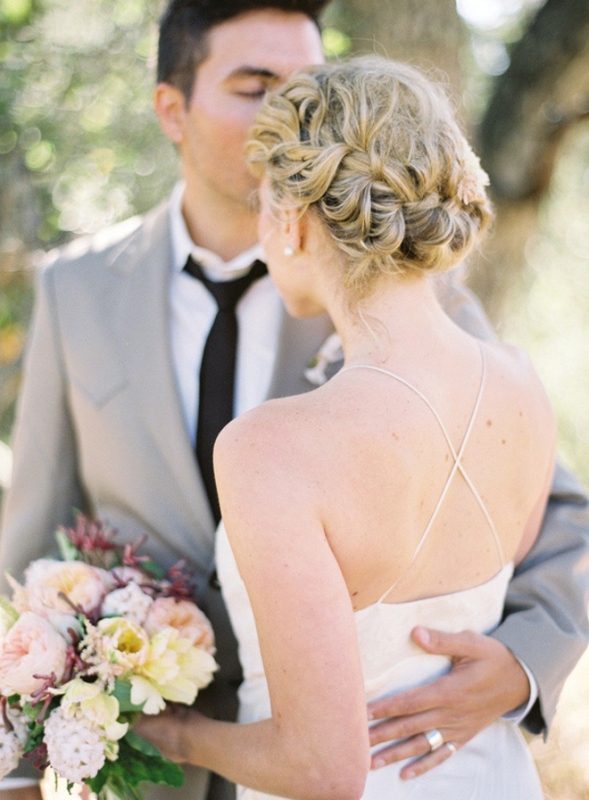 A braided updo with a messy top is an elegant and chic wedding hairstyle to try