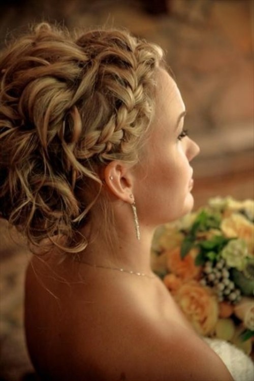 a wavy updo with a messy feel and a braided halo is a creative idea with much texture