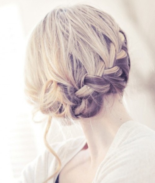 a laconic braided updo with some waves down is a durable and stylish hairstyle for a wedding