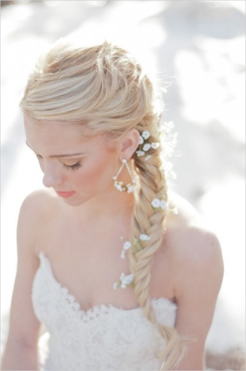 a messy fishtail braid with baby's breath tucked in for a more relaxed and boho chic look