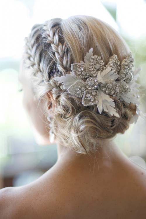 a low wavy updo with two braids and an embellished hairpiece for vintage elegance and chic