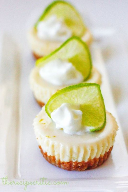delicious mini cheesecakes topped with whipped cream and lime slices for a fresh touch