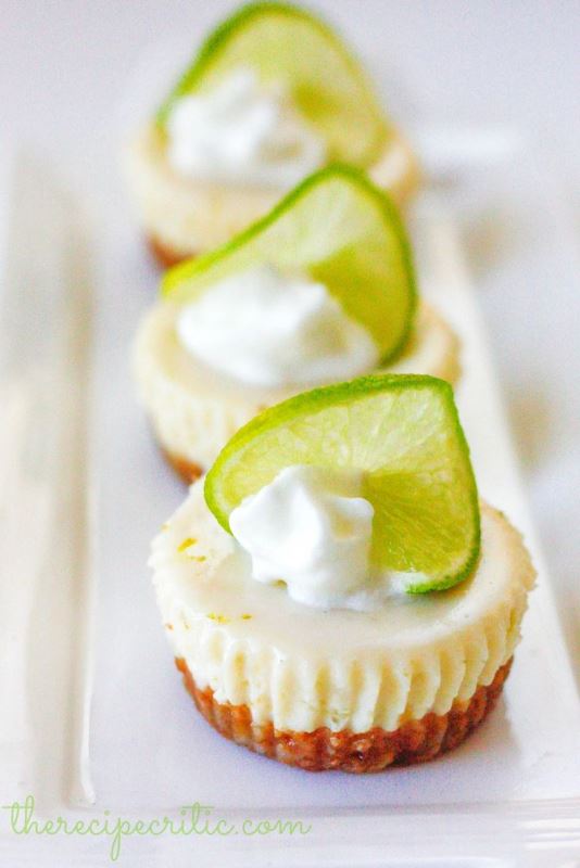 Delicious mini cheesecakes topped with whipped cream and lime slices for a fresh touch