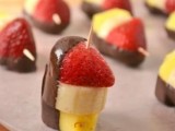 a pineapple, banana and strawberry kabob appetizer topped with chocolate