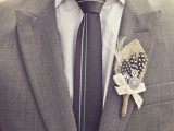 a grey suit, a white shirt, a grey striped tie and a cool feather boutonniere for a modern groom’s outfit