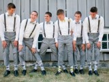 groomsmen wearing white shirts, black suspenders, grey pants, printed socks and black shoes