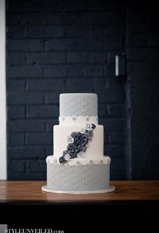 A grey and white wedding cake with textural tiers, navy sugar flowers looks unusual