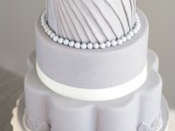 a whimsical grey wedding cake with various tiers, with beads, sugar blooms and creative shapes