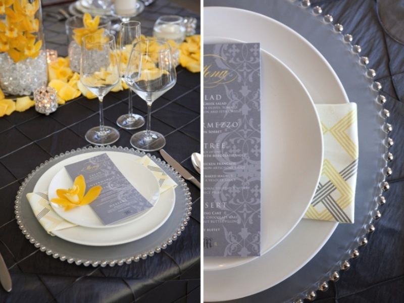 A refined graphite grey and bold yellow wedding tablescape with a petal garland and grey stationery