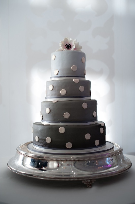 A multi tier wedding cake in various shades of grey and with polka dots is a cool idea to rock