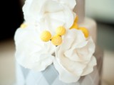 a grey wedding cake with a geometric tier and white sugar blooms is a cool idea rock for your wedding