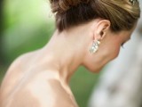 a chic twisted wedding updo with twists even on top and a shiny embellished hairpiece for a vintage or just formal bridal look