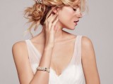 a messy wedding updo with a braided halo and a pearl hairpiece is a lovely and chic idea to rock