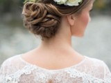 a chic low wedding updo with a twisted low bun and a small volume on top plus a floral crown is a beautiful idea that works for long and medium length hair