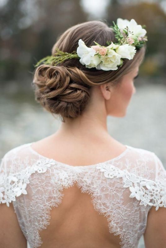 A chic low wedding updo with a twisted low bun and a small volume on top plus a floral crown is a beautiful idea that works for long and medium length hair