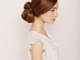 a low updo with a twisted bun and a sleek top is a bold and modern idea for a modern bride with long hair