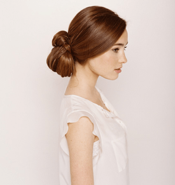 A low updo with a twisted bun and a sleek top is a bold and modern idea for a modern bride with long hair