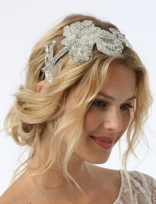 a messy and wavy low updo with some locks down and with an embellished headpiece is a gorgeous option for a bride who loves effortless chic