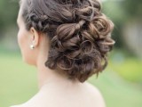 a twisted and curly wedding updo with a complicated and layered top and a braided halo for brides with long and extra long hair