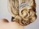 a wavy and chic low wedding updo with a wavy top and an embellished hairpiece is a chic and very exquisite option to go for