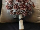 a cozy Christmas wedding bouquet of pinecones and white blooming branches is an ethreal and refined wedding bouquet