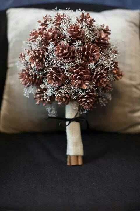 a cozy Christmas wedding bouquet of pinecones and white blooming branches is an ethreal and refined wedding bouquet