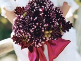 a beautiful winter wedding bouquet of deep purple dahlias and berries and dark leaves is a very refined and creative idea not only for a winter but also for a Christmas celebration
