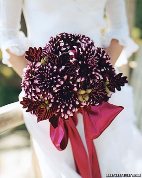 a beautiful winter wedding bouquet of deep purple dahlias and berries and dark leaves is a very refined and creative idea not only for a winter but also for a Christmas celebration