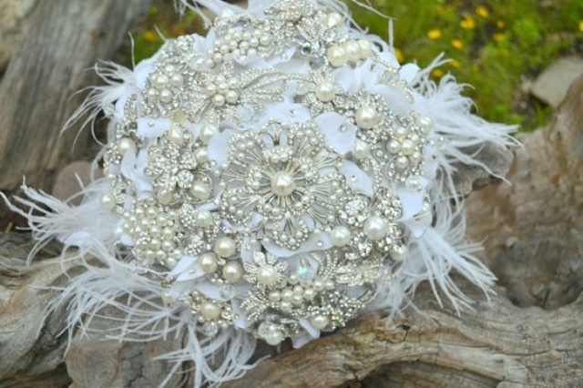 A vintage brooch and feather Christmas wedding bouquet is a fit for a vintage loving Christmas bride