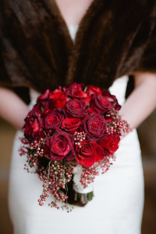 a red and burgundy rose wedding bouquet with red berries is a great idea for a Christmas bride