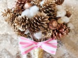a Christmas wedding bouquet of gilded berries, nuts and cotton with a striped bow for a non-traditional Christmas bride