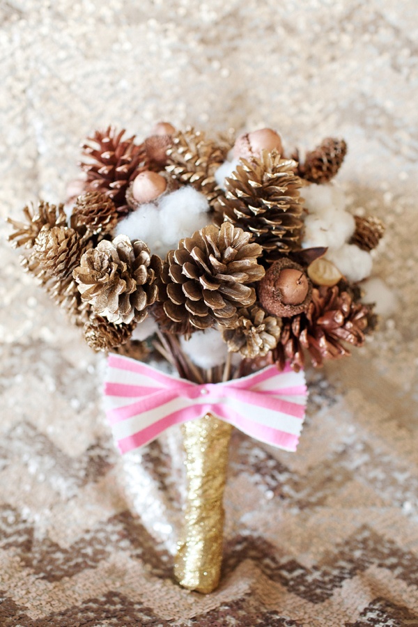 A Christmas wedding bouquet of gilded berries, nuts and cotton with a striped bow for a non traditional Christmas bride