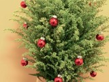 a unique Christmas wedding bouquet of green and tiny red Christmas ornaments is a very creative idea