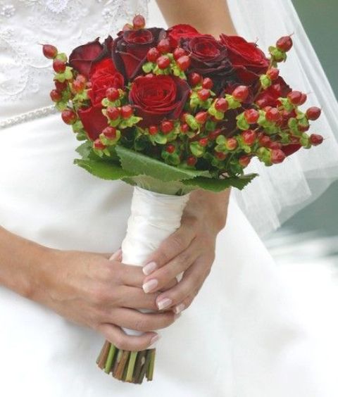 a traditional Christmas wedding bouquet of red roses, berries and leaves is a chic idea for a winter wedding