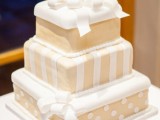 a tan and white Christmas wedding cake composed of gift boxes stacked on each other looks very whimsical