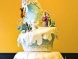 a whimsical Christmas wedding cake looking like a fantasy house covered with snow is a unique idea for a fairy-tale Christmas wedding