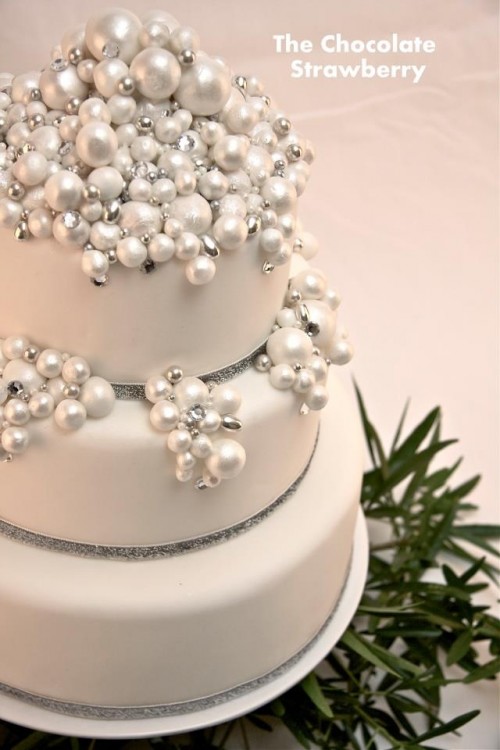 a white Christmas wedding cake decorated with pearls and white beads is a beautiful and very exquisite idea