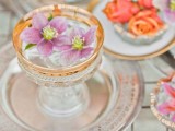 a gilded edge glass with a floating pink bloom is a lovely idea for a refined wedding