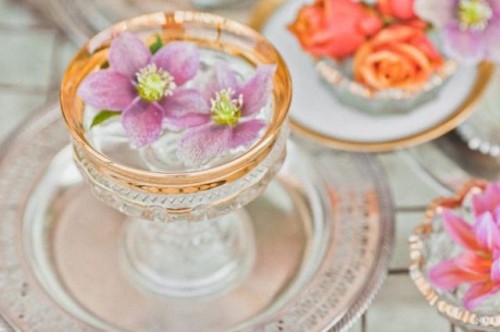 a gilded edge glass with a floating pink bloom is a lovely idea for a refined wedding